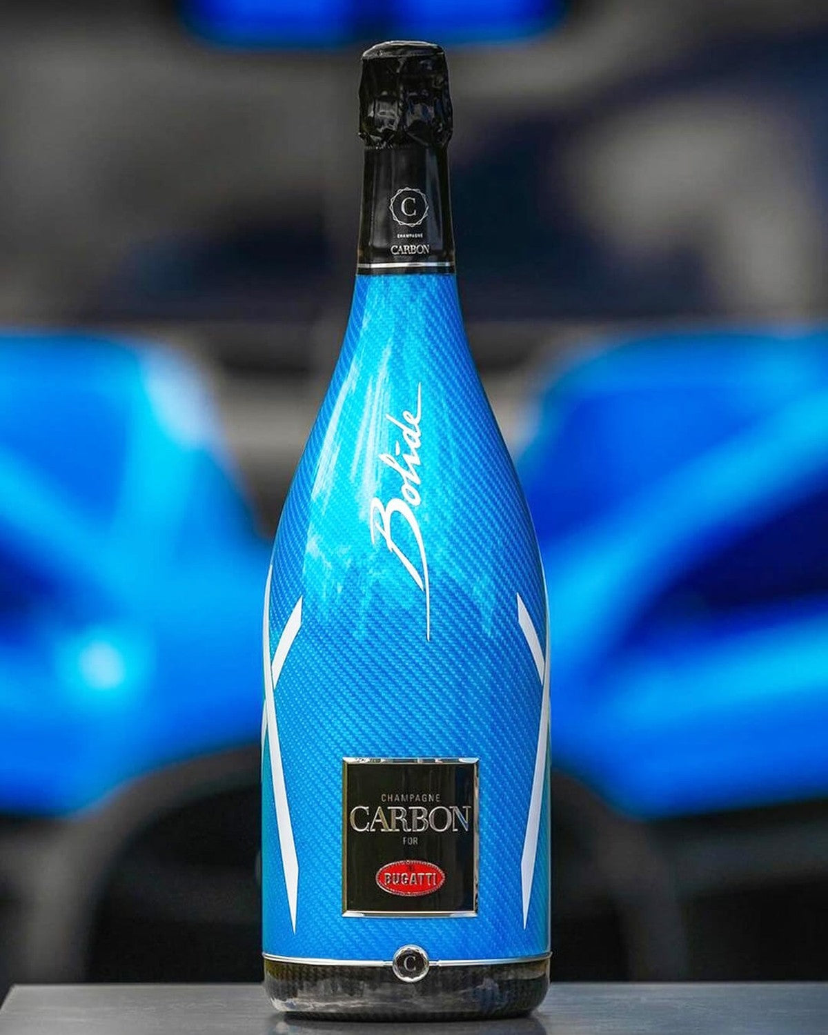 Carbon Bugatti Limited Edition Bolide 75CL — botella junto al coche